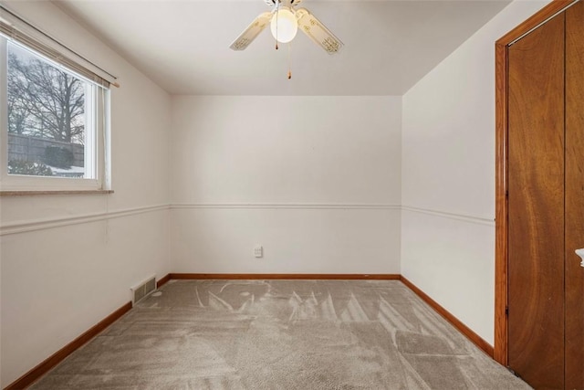 unfurnished room with light colored carpet, ceiling fan, visible vents, and baseboards