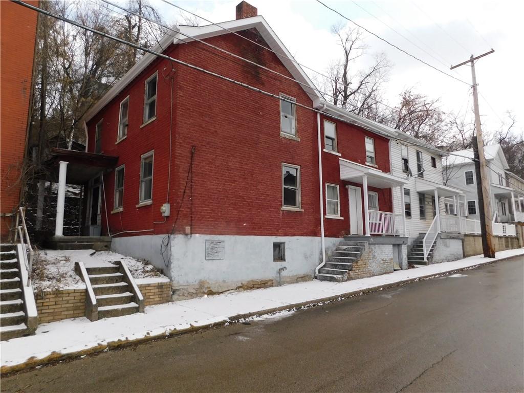 snow covered property featuring stairs