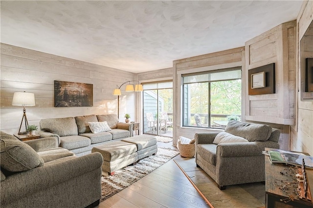 living area with wooden walls and wood finished floors