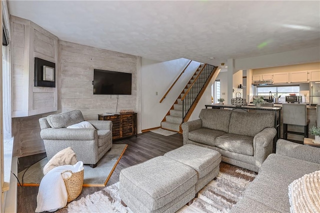 living room featuring stairs and dark wood-type flooring