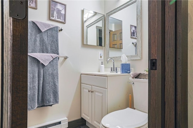 half bathroom featuring toilet, a baseboard heating unit, and vanity