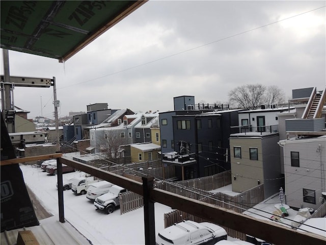 view of snow covered back of property