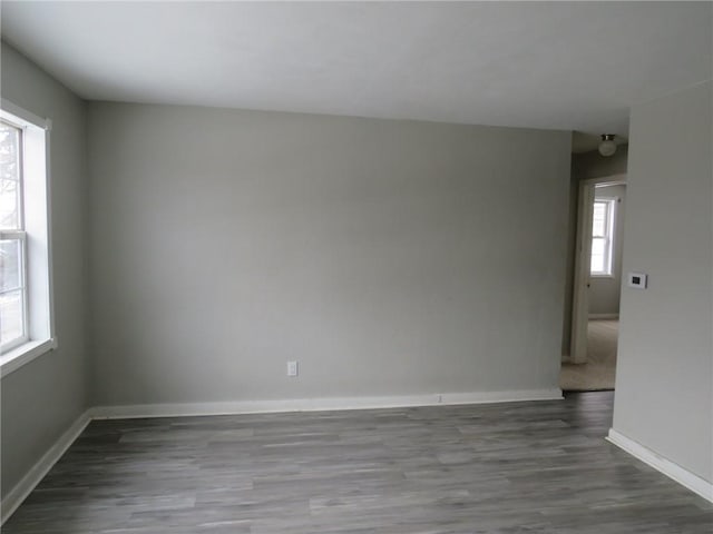 spare room featuring wood finished floors and baseboards