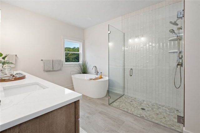 full bathroom with a stall shower, a freestanding tub, and vanity