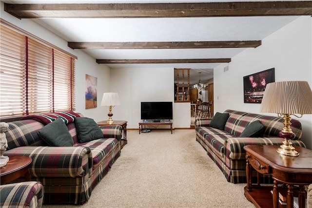 living room with beamed ceiling, a notable chandelier, and carpet