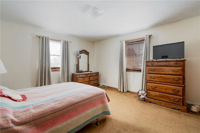 bedroom featuring light colored carpet and baseboards