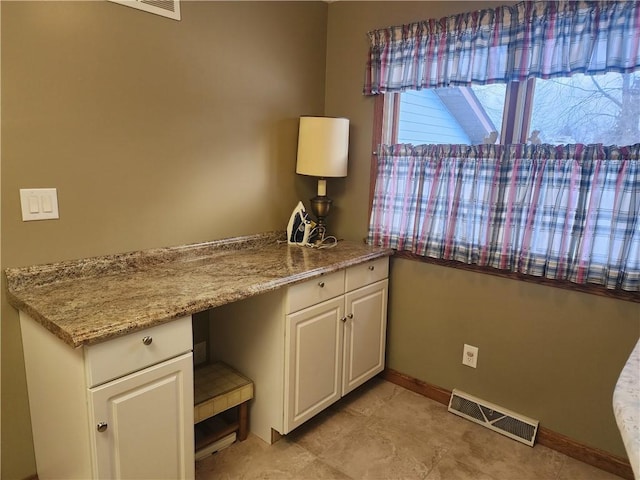 unfurnished office with baseboards and visible vents