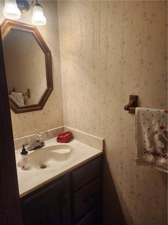 bathroom featuring wallpapered walls and vanity