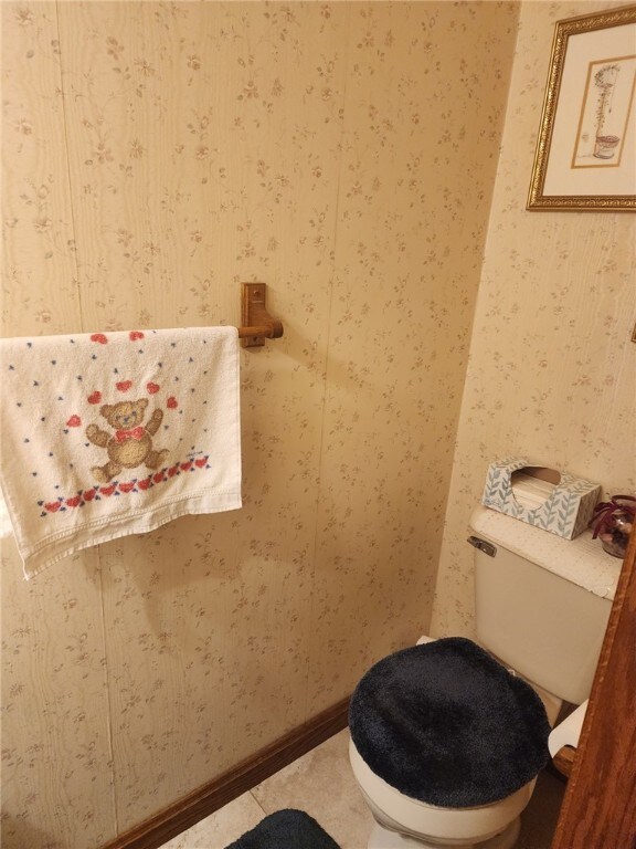 bathroom with toilet and wallpapered walls
