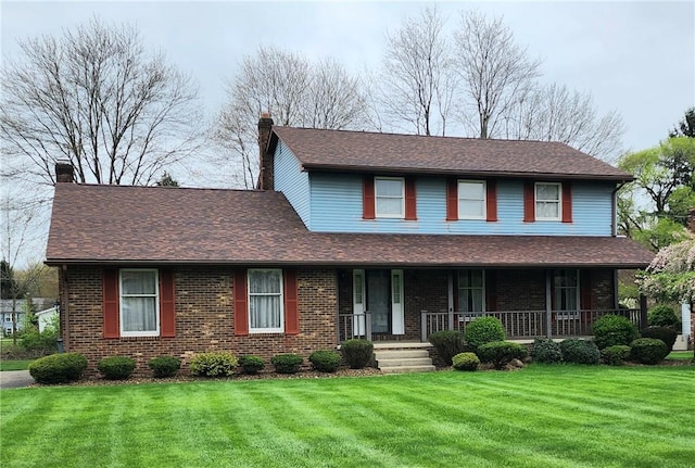 traditional home with a chimney, a porch, brick siding, a shingled roof, and a front lawn