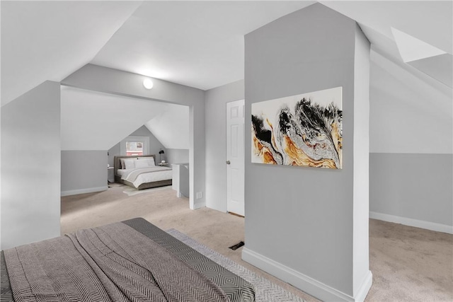 bedroom with light carpet, vaulted ceiling, and baseboards