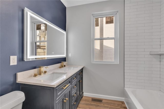 bathroom with toilet, baseboards, a sink, and wood finished floors