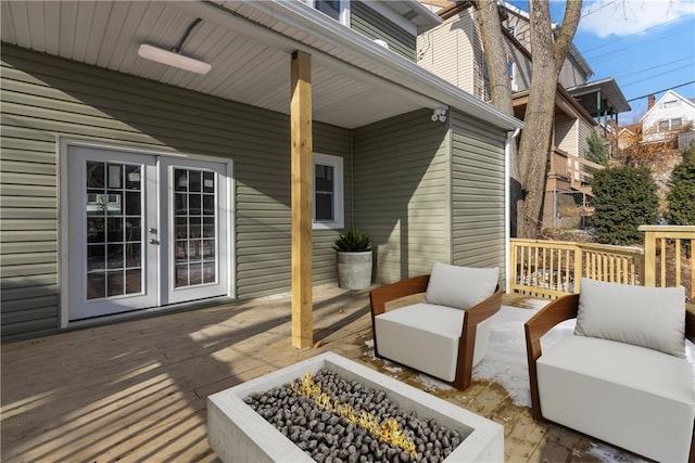 wooden deck featuring a fire pit and french doors