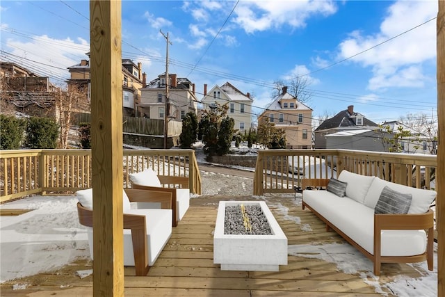 snow covered deck featuring a residential view and an outdoor living space with a fire pit