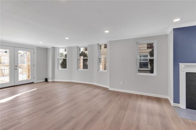 unfurnished living room featuring a fireplace with flush hearth, recessed lighting, baseboards, and light wood finished floors