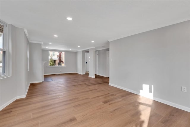 empty room with baseboards, ornamental molding, light wood-type flooring, and recessed lighting