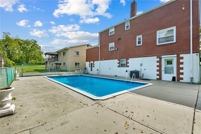 view of pool featuring fence, central AC unit, a fenced in pool, and a patio