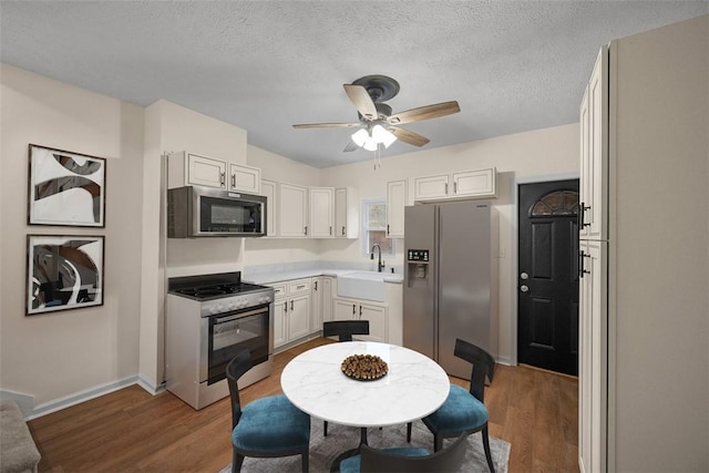 kitchen featuring light countertops, appliances with stainless steel finishes, a sink, and white cabinets