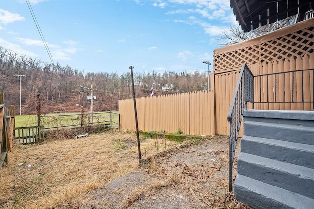 view of yard with stairway and fence