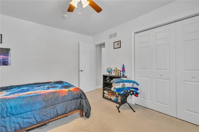 bedroom with a closet, visible vents, a ceiling fan, and light colored carpet