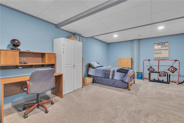 bedroom featuring light carpet, concrete block wall, and recessed lighting