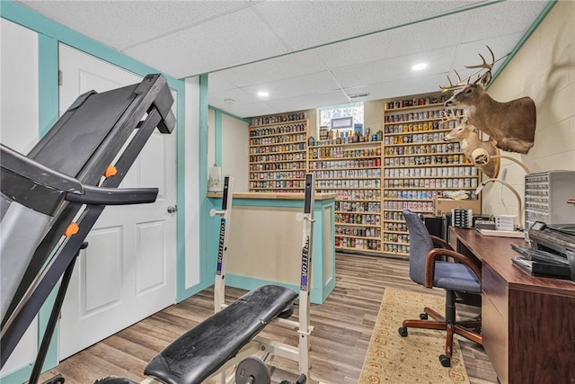 office space with light wood-type flooring, a paneled ceiling, and recessed lighting