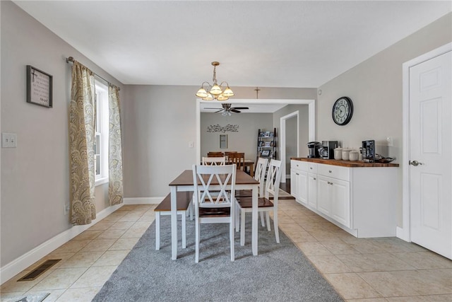 dining room with light tile patterned floors, a ceiling fan, visible vents, and baseboards