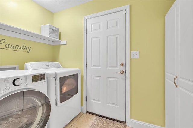 laundry room featuring laundry area, independent washer and dryer, light tile patterned flooring, and baseboards