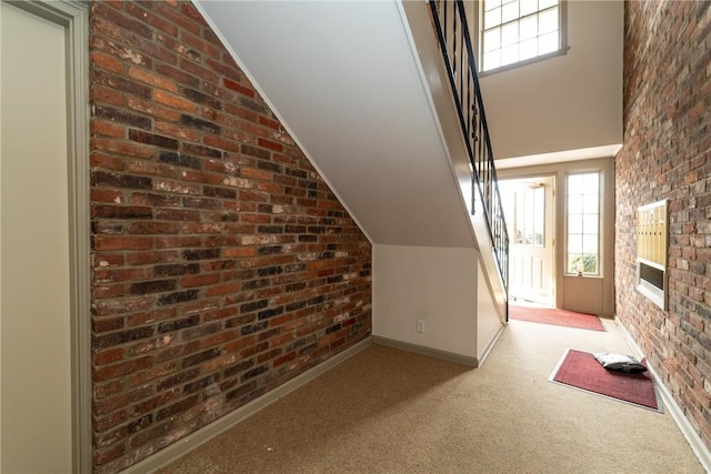 bonus room with baseboards, light colored carpet, vaulted ceiling, and brick wall