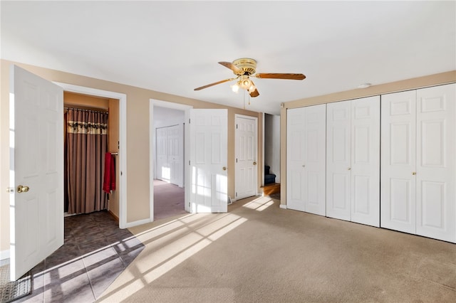 unfurnished bedroom featuring ceiling fan, baseboards, and light colored carpet