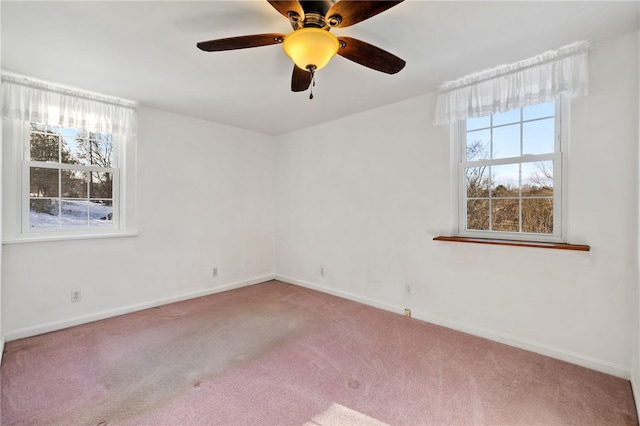 spare room featuring a wealth of natural light, carpet, and baseboards