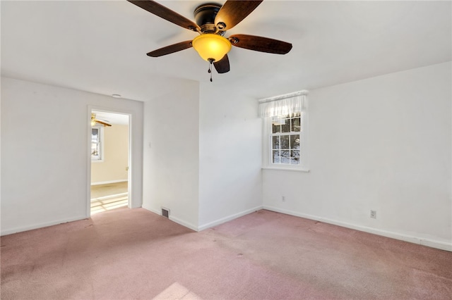 empty room with light carpet, visible vents, and baseboards