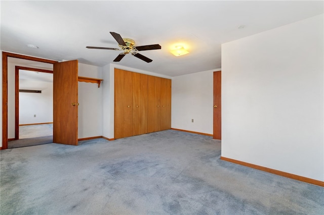 spare room featuring light carpet and baseboards