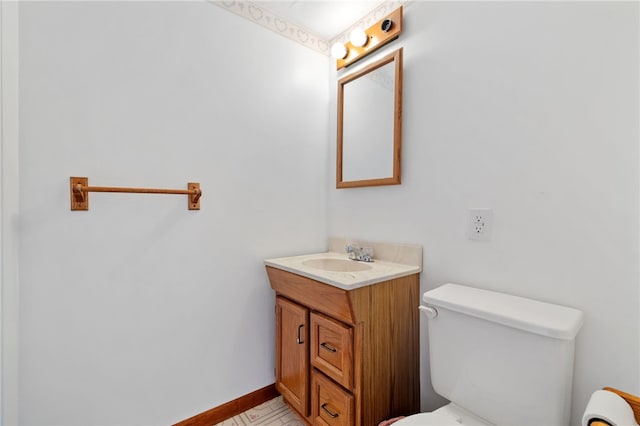 bathroom featuring vanity, toilet, and baseboards