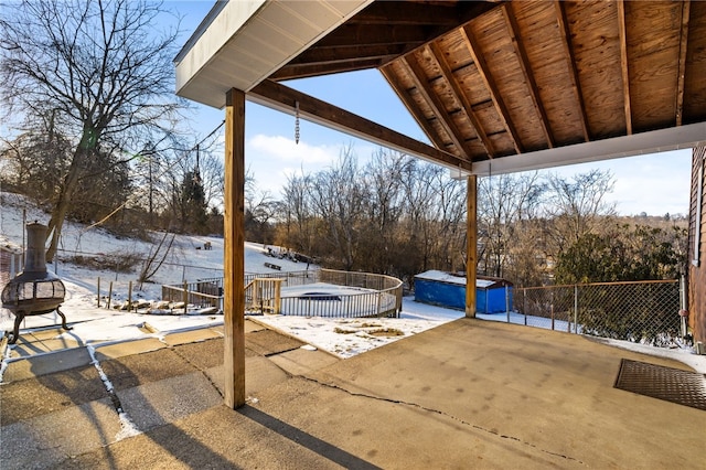 snow covered patio featuring a swimming pool and fence