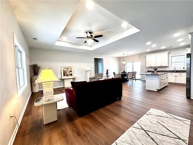 211 Ruby Dr, Menallen Twp, PA 15401 - living area featuring baseboards, a ceiling fan, a tray ceiling, and dark wood-style floors