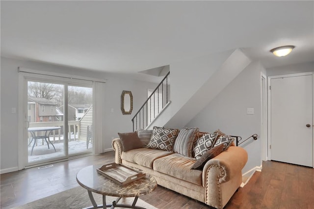 living area featuring stairs, wood finished floors, visible vents, and baseboards