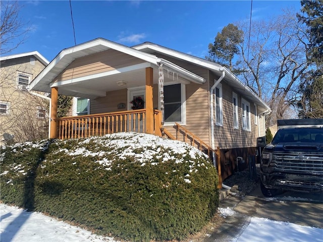 snow covered property with a porch