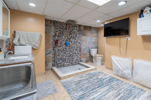 full bathroom featuring toilet, tile patterned floors, a tile shower, vanity, and recessed lighting