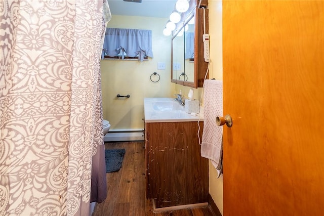 bathroom with a baseboard radiator, wood finished floors, and vanity