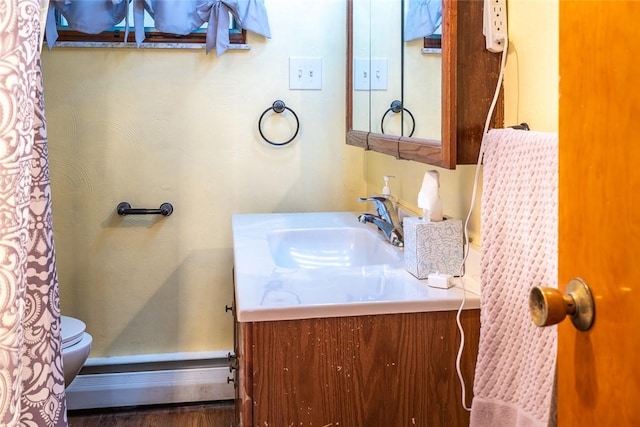 bathroom with a baseboard radiator, vanity, and toilet