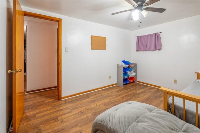 bedroom featuring wood finished floors, a ceiling fan, and baseboards