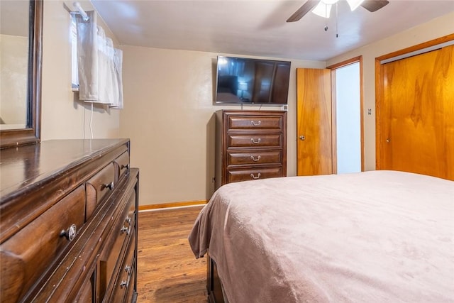 bedroom with a ceiling fan, baseboards, and wood finished floors