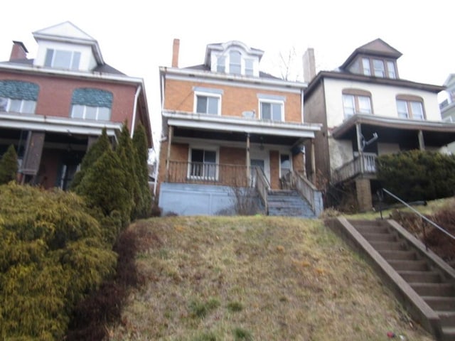 american foursquare style home featuring stairs and a porch