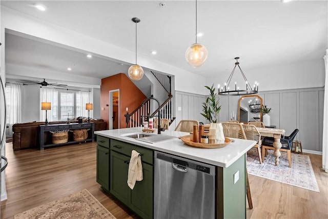 kitchen with dishwasher, decorative light fixtures, a kitchen island with sink, light countertops, and green cabinets