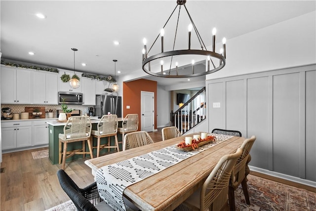 dining room featuring stairs, a decorative wall, dark wood finished floors, and recessed lighting