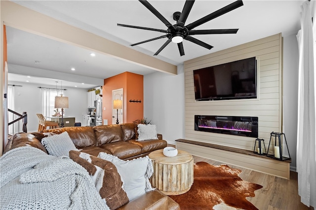 living room featuring beam ceiling, recessed lighting, a large fireplace, ceiling fan, and wood finished floors