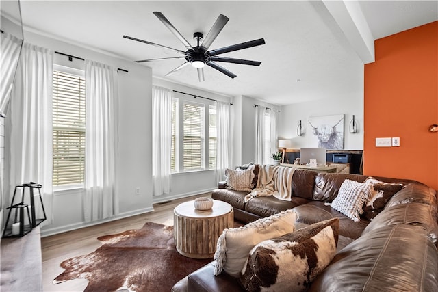 living room featuring light wood finished floors, baseboards, and a ceiling fan