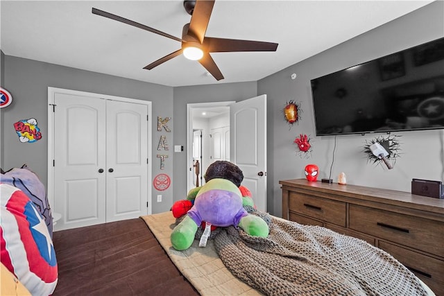 bedroom with dark wood-type flooring, a closet, and a ceiling fan