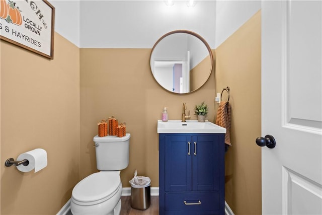 bathroom featuring baseboards, vanity, and toilet